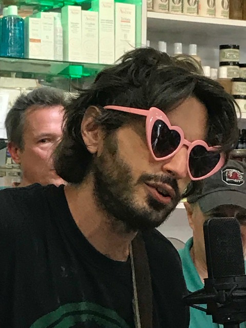 a man with heart shaped sun glasses singing at the Thompson Street Medicine Show